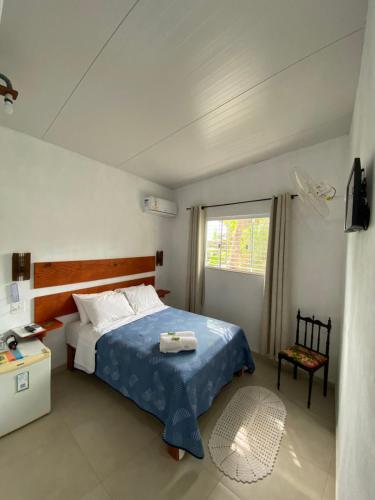 um quarto com uma cama azul e uma janela em Casa Caiçara em Praia de Araçatiba