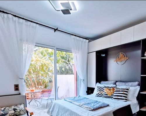 une chambre avec un lit et une grande fenêtre dans l'établissement Cocon Marin 4 Studio Proche Mer Parking wifi, à Cagnes-sur-Mer