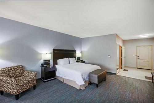 um quarto de hotel com uma cama e uma cadeira em Hampton Inn & Suites Houston/League City em League City