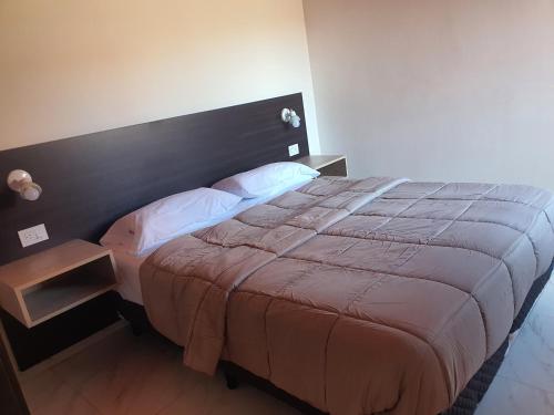 een slaapkamer met een groot bed met een houten hoofdeinde bij Complejo familia Yedynak in San Rafael