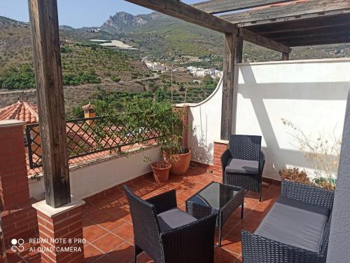 a balcony with chairs and a view of mountains at El Picacho de Ítrabo Ático in Ítrabo
