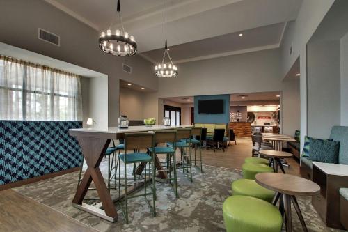 a lobby with a bar and some chairs and tables at Hampton Inn & Suites By Hilton Southport in Southport