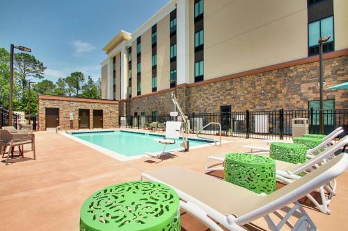 a patio with chairs and a swimming pool at Hampton Inn & Suites By Hilton Southport in Southport