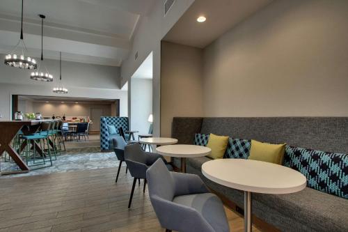 a restaurant with tables and chairs and a bar at Hampton Inn & Suites By Hilton Southport in Southport