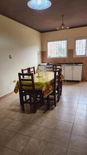 Brown Alojamientos Temporarios في سالتا: غرفة طعام مع طاولة وكراسي ومطبخ