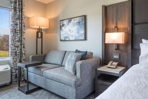 a hotel room with a couch and a bed at Hilton Garden Inn Hanover Lebanon in Lebanon