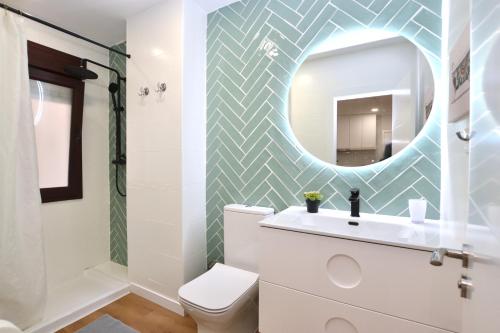 ein Badezimmer mit einem weißen WC und einem Spiegel in der Unterkunft STAY Rosal in Oviedo