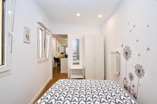 a white bedroom with a bed and a kitchen at STAY Rosal in Oviedo