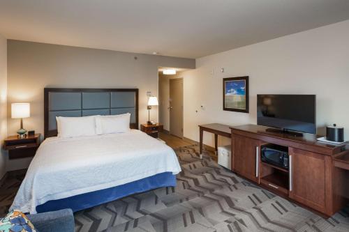 a hotel room with a bed and a flat screen tv at Hampton Inn Lewiston, ID in Lewiston