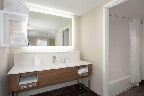 a bathroom with a sink and a mirror and a shower at Hampton Inn & Suites Kansas City-Merriam in Merriam