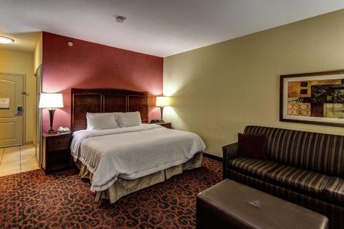 a hotel room with a bed and a couch at Hampton Inn Junction City in Junction City