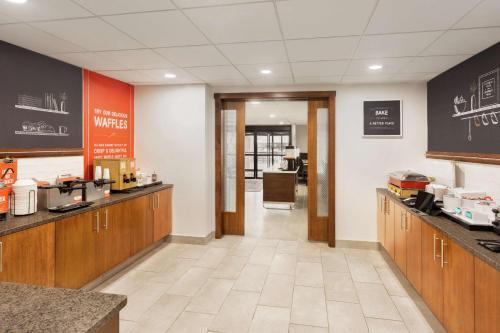 a kitchen with wooden cabinets and a cafeteria at Hampton Inn Milwaukee Brookfield in Brookfield