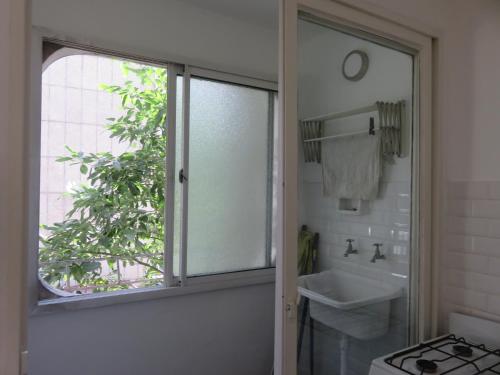 un bagno con finestra accanto a lavandino e lavandino di Oasis Palermo Soho a Buenos Aires