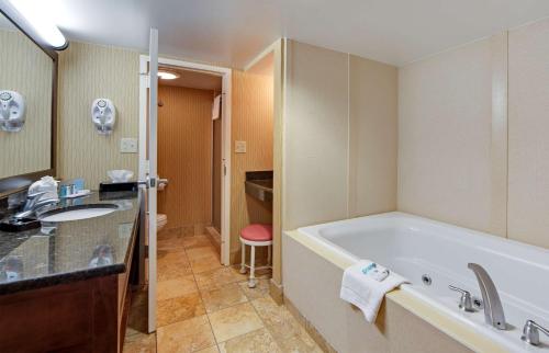 a bathroom with a tub and a sink at Hampton Inn Myrtle Beach Broadway at the Beach in Myrtle Beach