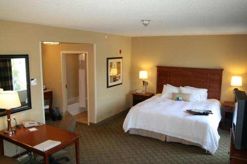 Hampton Inn & Suites Paducah في بادوكا: غرفه فندقيه سرير وتلفزيون