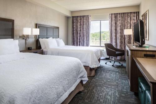 a hotel room with two beds and a television at Hampton Inn Council Bluffs in Council Bluffs