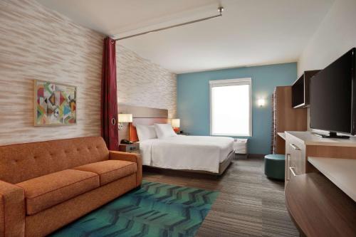 um quarto de hotel com uma cama e um sofá em Home2 Suites By Hilton Warminster Horsham em Warminster