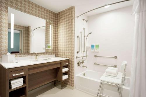 uma casa de banho com um lavatório, uma banheira e um chuveiro em Home2 Suites By Hilton Warminster Horsham em Warminster