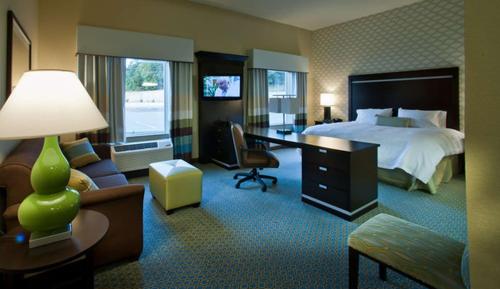 ein Hotelzimmer mit einem Bett und einem Schreibtisch in der Unterkunft Hampton Inn & Suites Denison in Denison