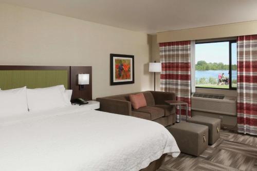 a hotel room with a large bed and a couch at Hampton Inn Richland-Tri Cities in Richland