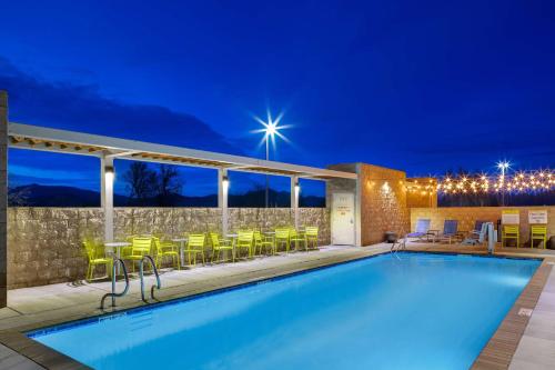 a swimming pool at night with chairs and tables at Home2 Suites By Hilton Redding in Redding