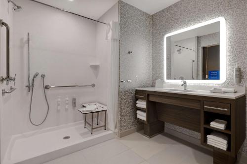 a bathroom with a tub and a sink and a mirror at Home2 Suites By Hilton Redding in Redding