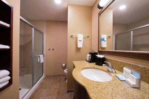 een badkamer met een wastafel, een toilet en een spiegel bij Hampton Inn & Suites Rifle in Rifle