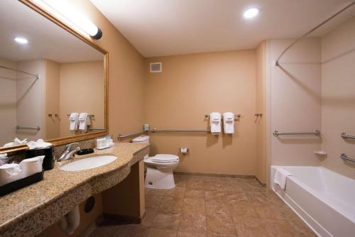 a bathroom with a sink and a toilet and a tub at Hampton Inn & Suites Rifle in Rifle