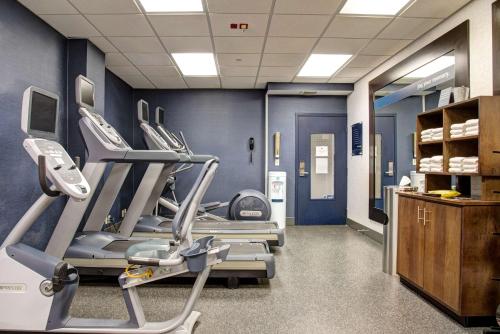 a gym with several tread machines in a room at Hampton Inn Rochester in Rochester