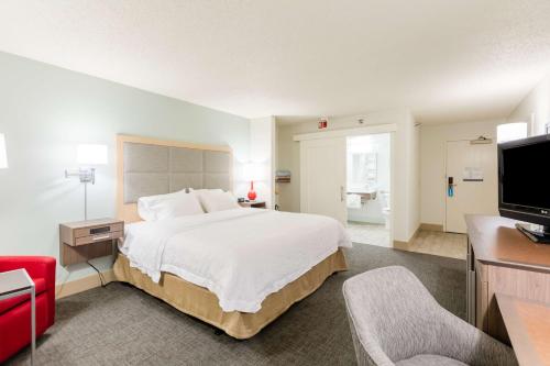 a hotel room with a large bed and a television at Hampton Inn Rochester in Rochester