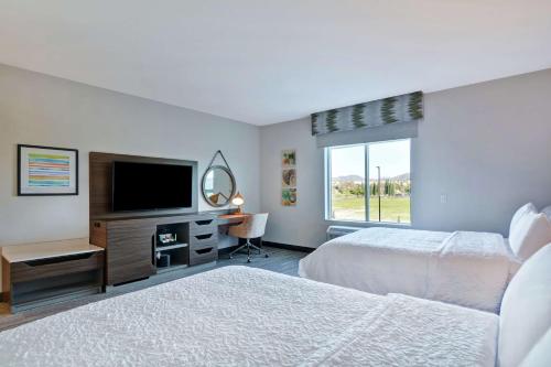 a bedroom with two beds and a flat screen tv at Hampton Inn Chula Vista Eastlake in Chula Vista