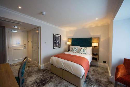 a bedroom with a bed and a desk and a chair at Best Western Abbots Barton Hotel in Canterbury
