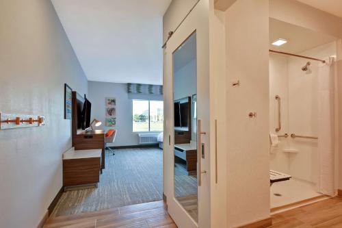 um corredor com uma porta que dá acesso a um quarto com uma secretária em Hampton Inn Chula Vista Eastlake em Chula Vista