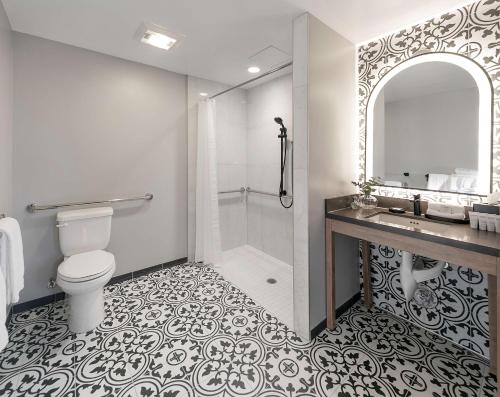 a bathroom with a shower and a toilet and a sink at Hotel Virginia Santa Barbara, Tapestry Collection by Hilton in Santa Barbara