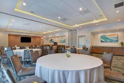 a conference room with tables and chairs and a screen at Hampton Inn Chula Vista Eastlake in Chula Vista