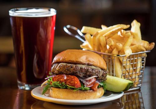 a plate with a hamburger and french fries and a drink at DoubleTree Suites by Hilton Hotel Detroit Downtown - Fort Shelby in Detroit