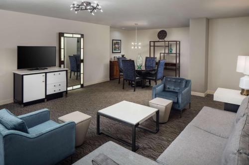 a living room with a couch and chairs and a tv at DoubleTree Suites by Hilton Hotel Detroit Downtown - Fort Shelby in Detroit