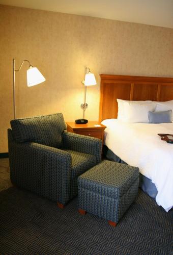 a hotel room with a bed and a chair at Hampton Inn San Marcos in San Marcos