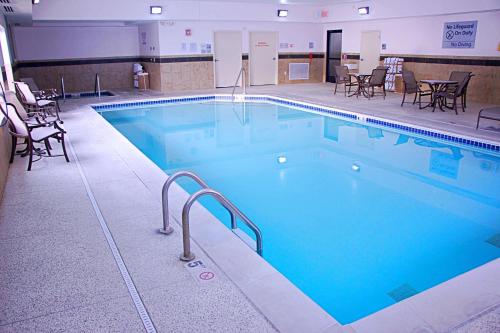 una gran piscina en un edificio con sillas y mesas en Hampton Inn Sidney, en Sidney