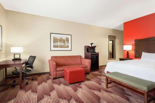 硫磺泉鎮的住宿－硫磺泉漢普頓酒店，酒店客房配有一张床、一张桌子和一把椅子。