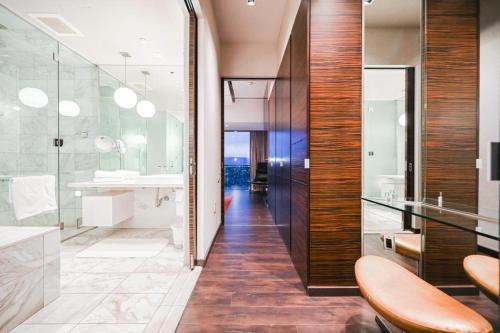 y baño con ducha acristalada y lavamanos. en Intimo Palms Place Penthouse en Las Vegas