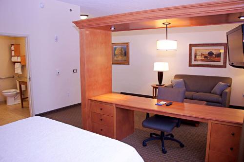 a hotel room with a desk and a bed at Hampton Inn Sidney in Sidney