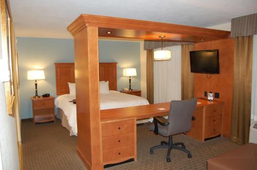 a hotel room with a bed and a desk with a computer at Hampton Inn Sidney in Sidney