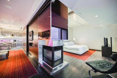 a living room with a fireplace and a bed at Intimo Palms Place Penthouse in Las Vegas