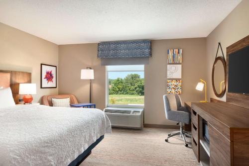 a hotel room with a bed and a window at Hampton Inn St. Louis-Columbia in Millstadt Junction