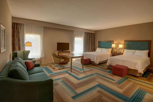 une chambre d'hôtel avec deux lits et un canapé dans l'établissement Hampton Inn Plant City, à Plant City