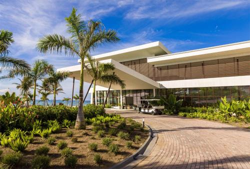 un edificio con palmeras delante en Sonesta Ocean Point Resort- All Inclusive - Adults Only, en Maho Reef