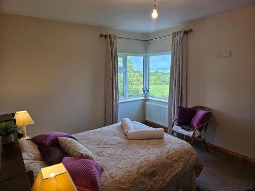 a bedroom with a large bed and a window at Hillview House 