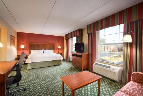 a hotel room with a bed and a large window at Hampton Inn & Suites Williamsburg-Central in Williamsburg
