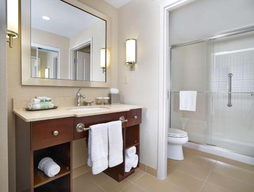 a bathroom with a sink and a toilet and a mirror at Homewood Suites by Hilton Halifax - Downtown in Halifax